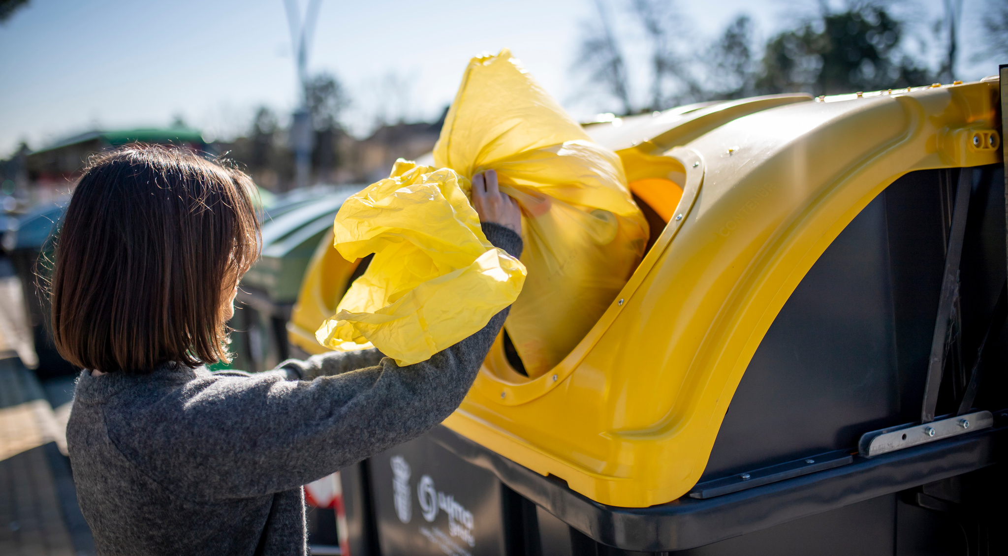 Una ciudadana echa al contenedor algunos residuos reciclables.