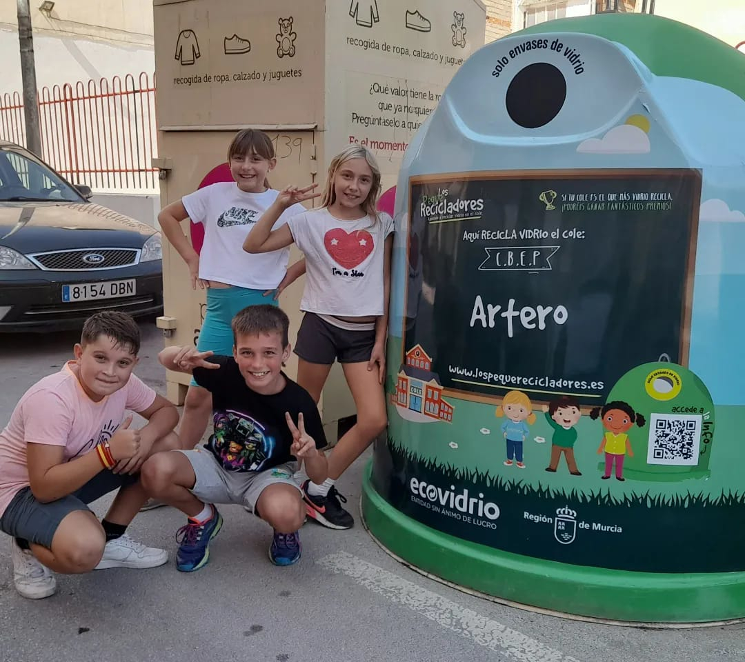 Alumnos de Primaria junto a un contenedor de vidrio durante la campaña 'Los Pequeños Recicladores'