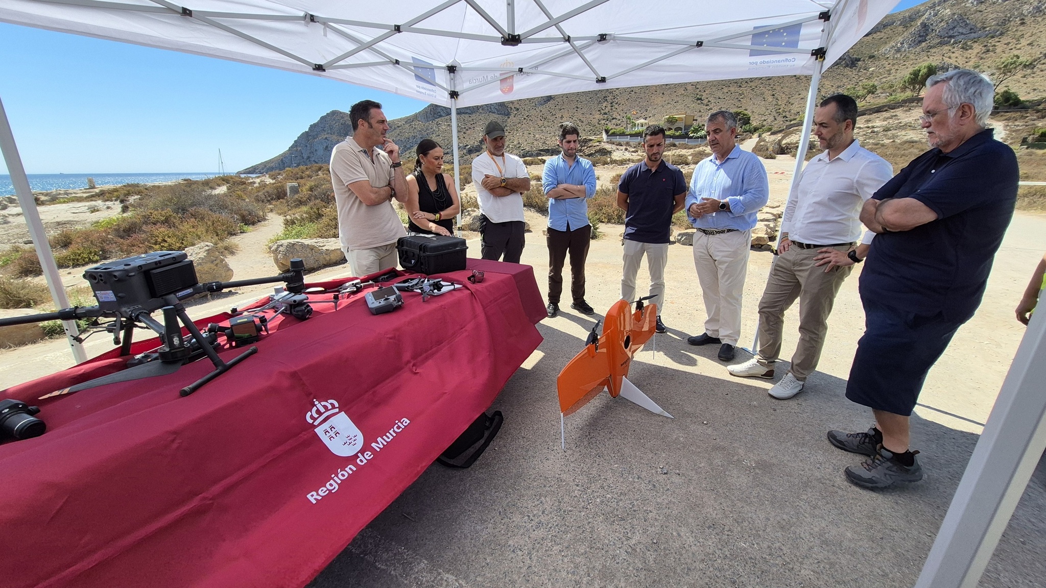 El consejero, Juan María Vázquez, durante la presentación de los nuevos drones de vigilancia del servicio de Inspección Ambiental en el Parque Regional de Cabo Cope y Puntas de Calnegre (Águilas) y el equipo de drones del servicio de Inspección Ambiental volando sobre el Parque.